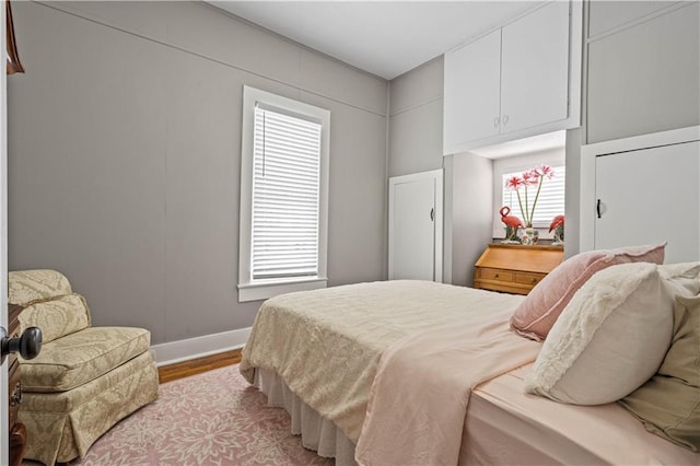 bedroom with light wood-style floors and baseboards