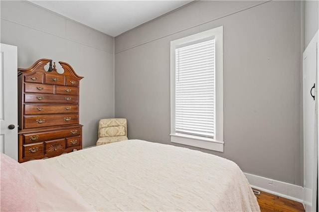 bedroom featuring visible vents and wood finished floors