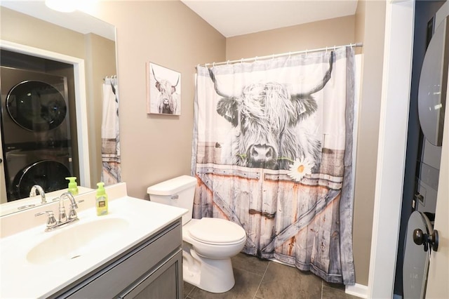 bathroom with a shower with curtain, stacked washer and dryer, vanity, and toilet