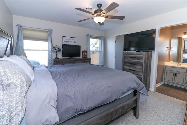 tiled bedroom featuring ensuite bathroom, sink, and ceiling fan