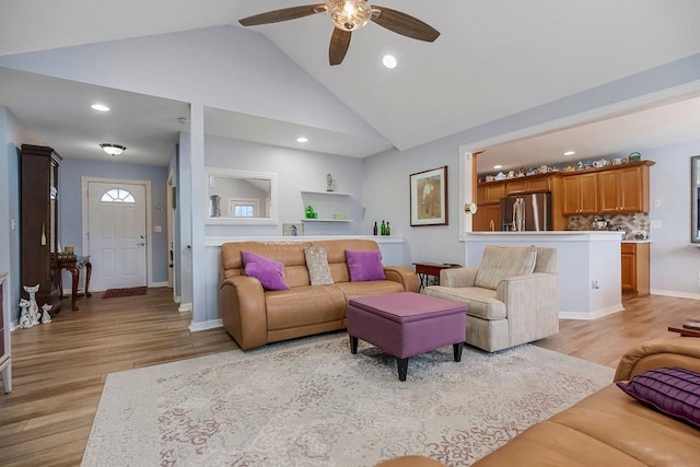 living room with ceiling fan, high vaulted ceiling, and light wood-type flooring