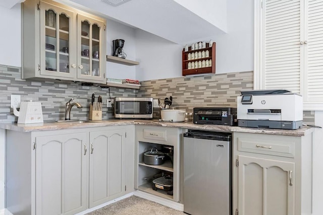 kitchen featuring tasteful backsplash, sink, white cabinetry, and stainless steel appliances