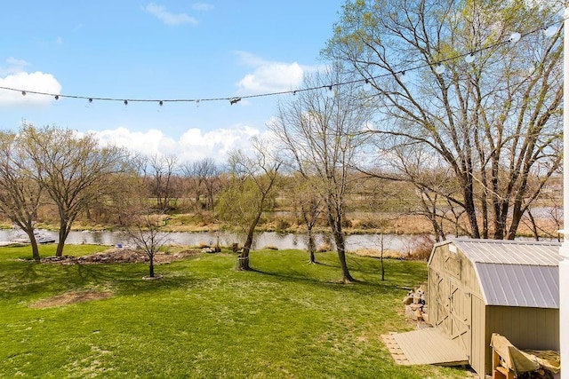 view of yard featuring a water view and a shed