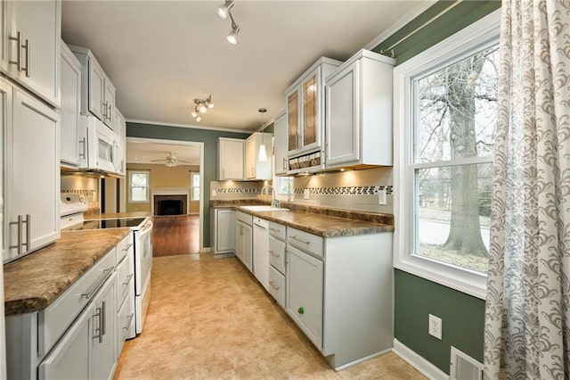 kitchen with hanging light fixtures, white cabinetry, sink, and white appliances