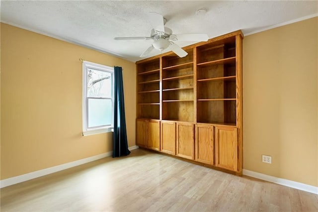 empty room featuring a textured ceiling, light hardwood / wood-style flooring, and ceiling fan