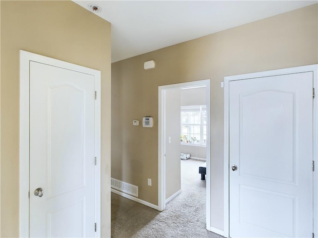 hallway featuring light colored carpet