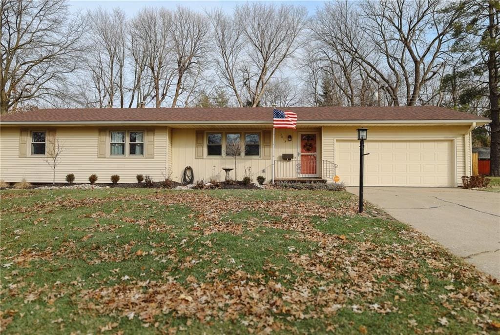 ranch-style house with a garage and a front lawn