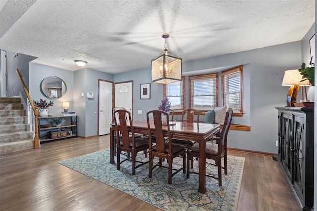 dining area with a textured ceiling and dark hardwood / wood-style flooring