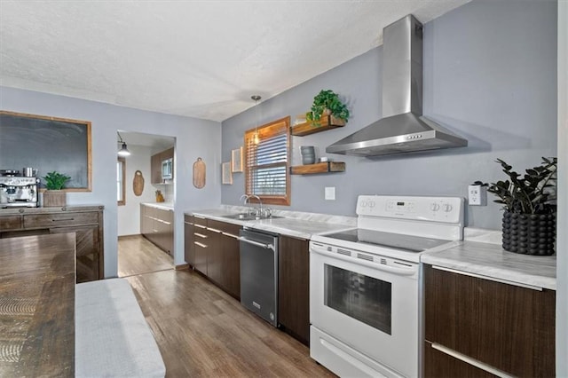 kitchen featuring sink, hardwood / wood-style flooring, white range with electric cooktop, stainless steel dishwasher, and wall chimney exhaust hood