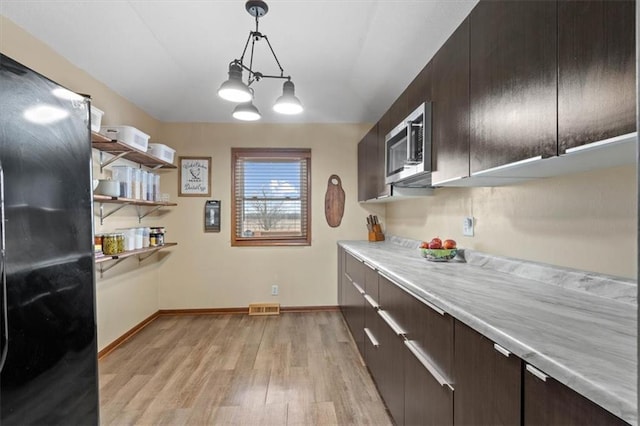 kitchen featuring pendant lighting, dark brown cabinetry, and light hardwood / wood-style flooring