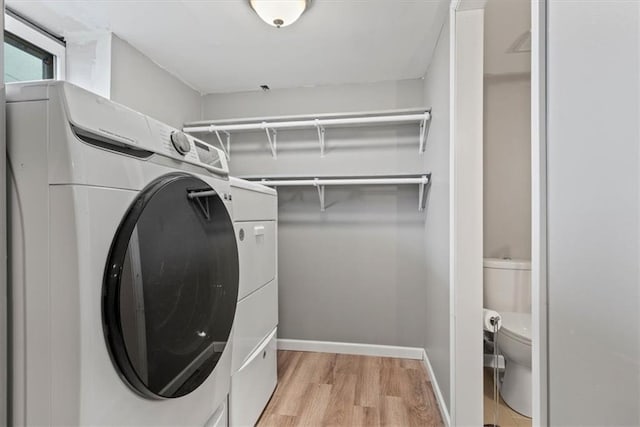 laundry room featuring washer and clothes dryer and light hardwood / wood-style flooring