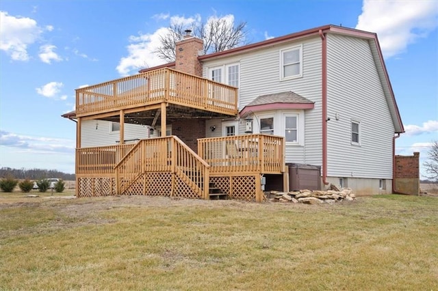 back of house featuring a deck, a covered hot tub, and a lawn