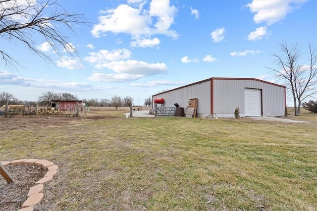 view of yard featuring a garage, an outbuilding, and an outdoor structure