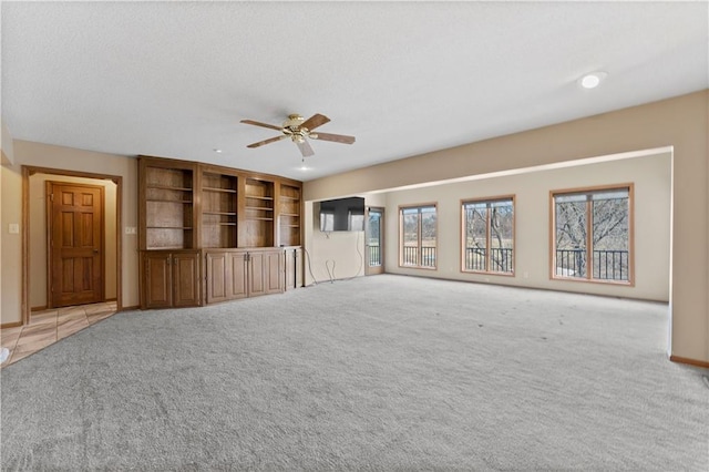 unfurnished living room featuring light carpet and ceiling fan