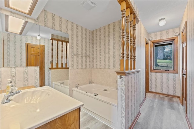 bathroom featuring vanity, a tub to relax in, and hardwood / wood-style flooring