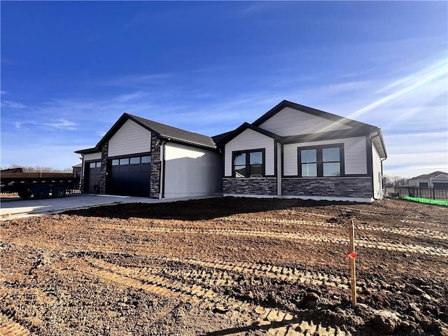 ranch-style house featuring a garage, stone siding, and concrete driveway