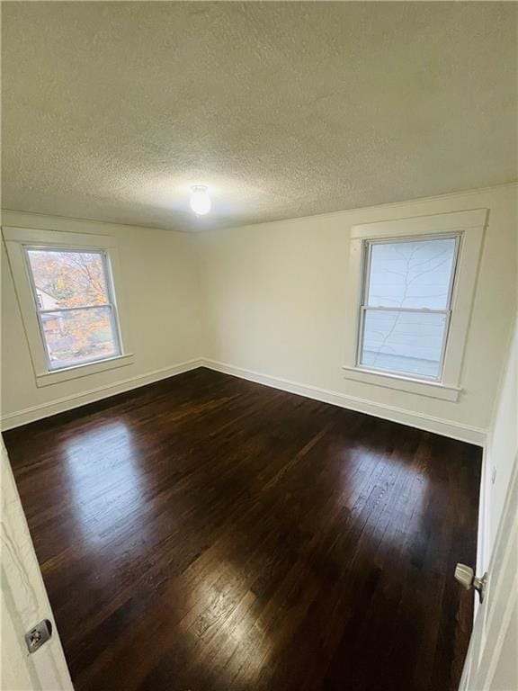 unfurnished room featuring wood-type flooring and a textured ceiling