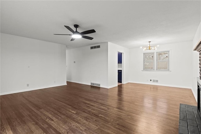 unfurnished living room with ceiling fan with notable chandelier and dark hardwood / wood-style floors