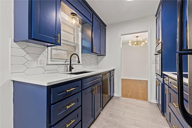 kitchen featuring blue cabinets, sink, tasteful backsplash, a chandelier, and appliances with stainless steel finishes