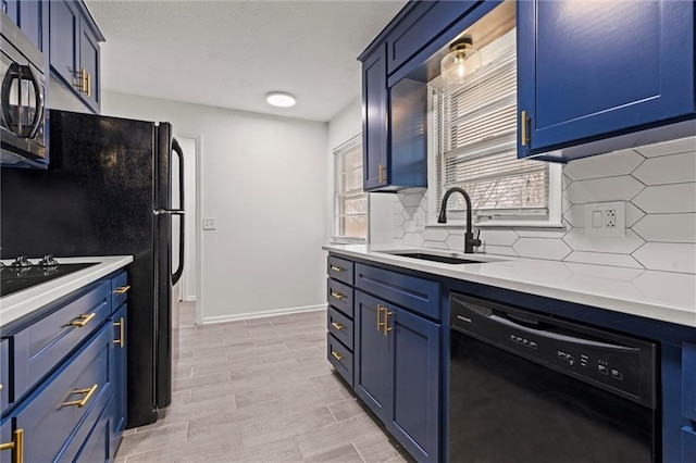 kitchen featuring sink, blue cabinetry, and black dishwasher