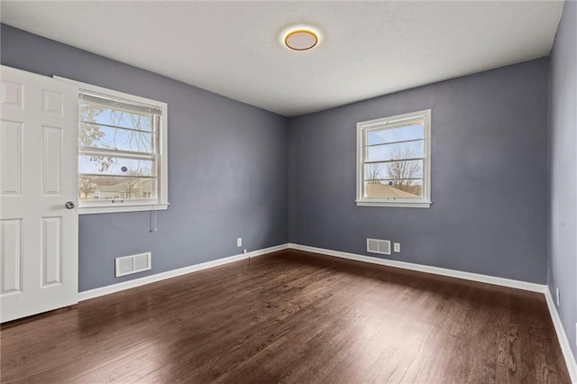 spare room featuring dark hardwood / wood-style floors