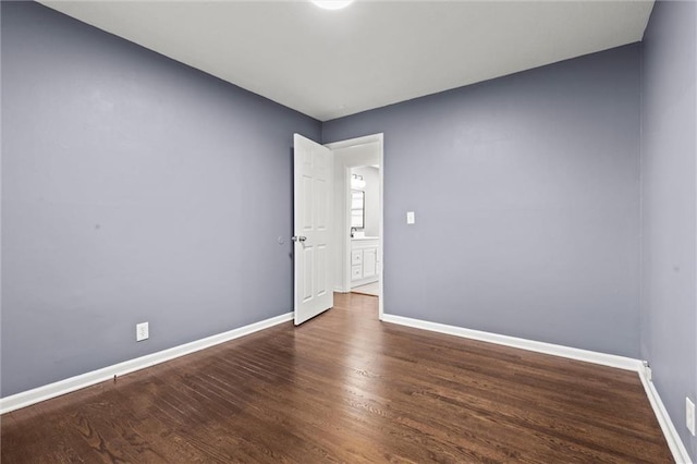 unfurnished room with dark wood-type flooring