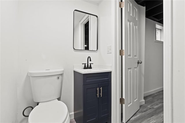 bathroom featuring vanity, wood-type flooring, and toilet