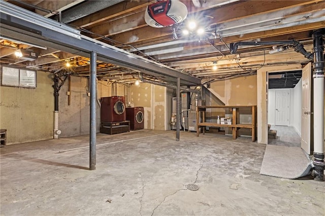 basement featuring water heater, washer and dryer, and heating unit