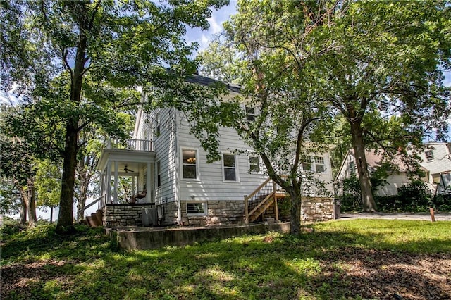 back of property with a yard and a balcony