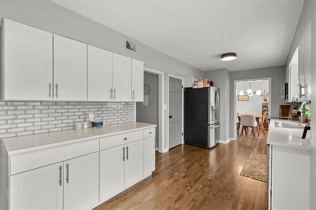 kitchen featuring sink, appliances with stainless steel finishes, white cabinets, hardwood / wood-style floors, and backsplash