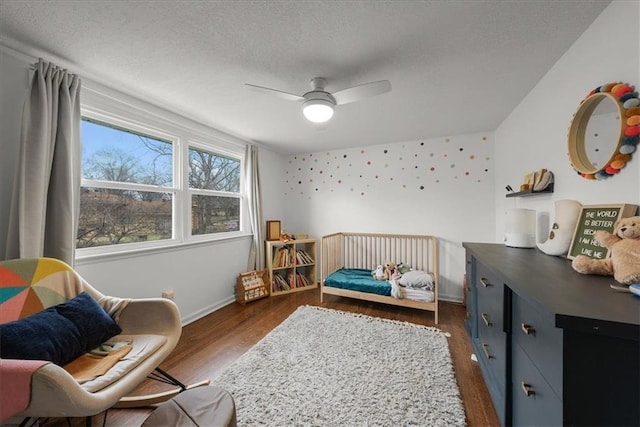 bedroom featuring ceiling fan, dark hardwood / wood-style floors, and a textured ceiling