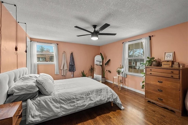 bedroom featuring ceiling fan, hardwood / wood-style floors, and a textured ceiling