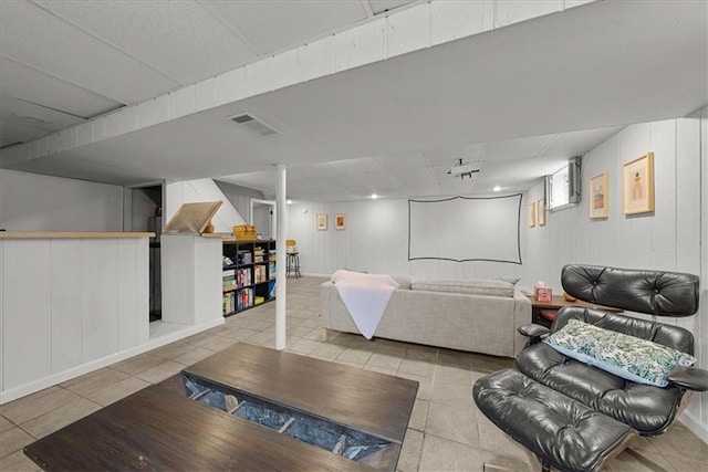 tiled living room featuring a drop ceiling