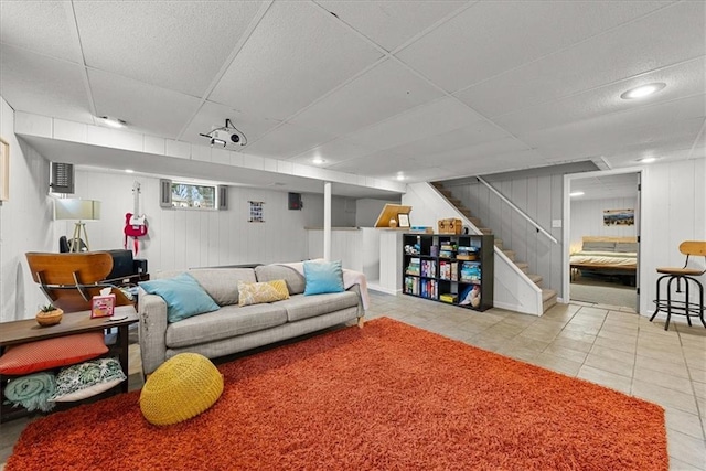 living room featuring a paneled ceiling and light tile patterned floors