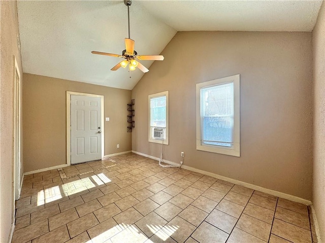 empty room with light tile patterned flooring, vaulted ceiling, cooling unit, and ceiling fan