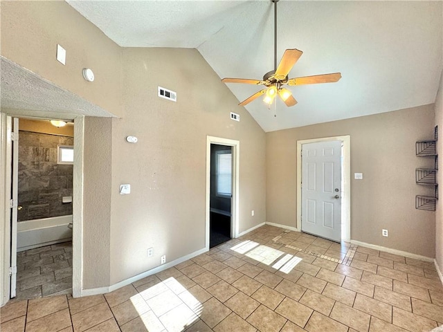 spare room featuring light tile patterned flooring, high vaulted ceiling, and ceiling fan