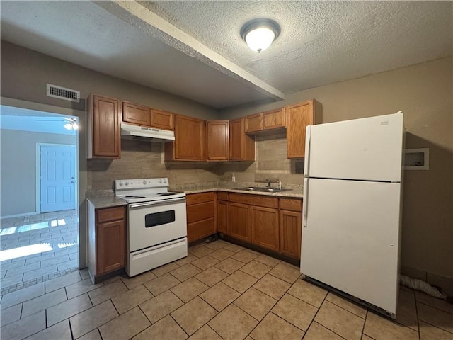 kitchen with light tile patterned flooring, tasteful backsplash, sink, white appliances, and a textured ceiling