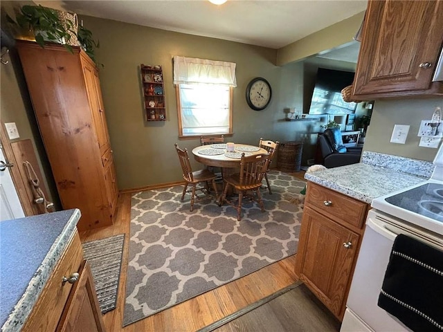 kitchen with white electric range, light stone countertops, and dark hardwood / wood-style floors