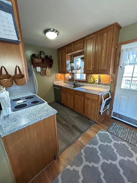 kitchen with stovetop, sink, dishwashing machine, light stone countertops, and dark wood-type flooring