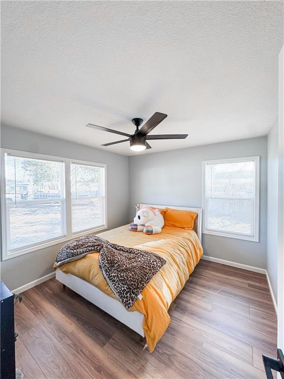 bedroom with wood-type flooring, a textured ceiling, and ceiling fan