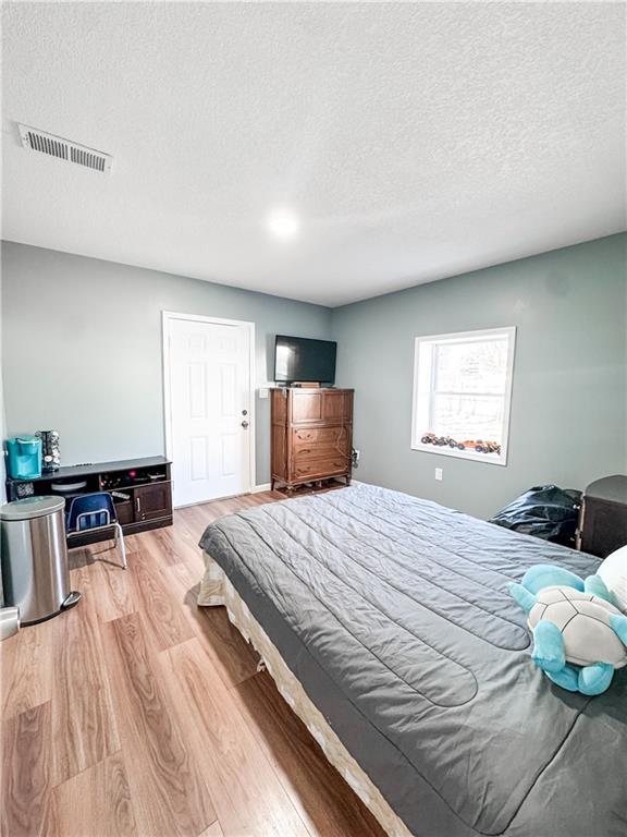 bedroom featuring a textured ceiling and light wood-type flooring