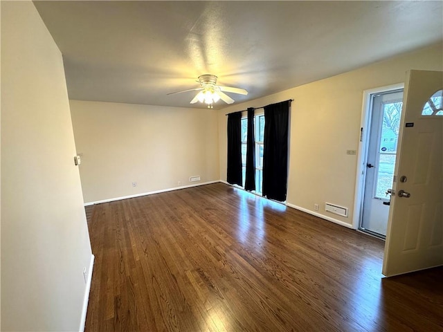 unfurnished room with dark wood-style floors, baseboards, and a ceiling fan