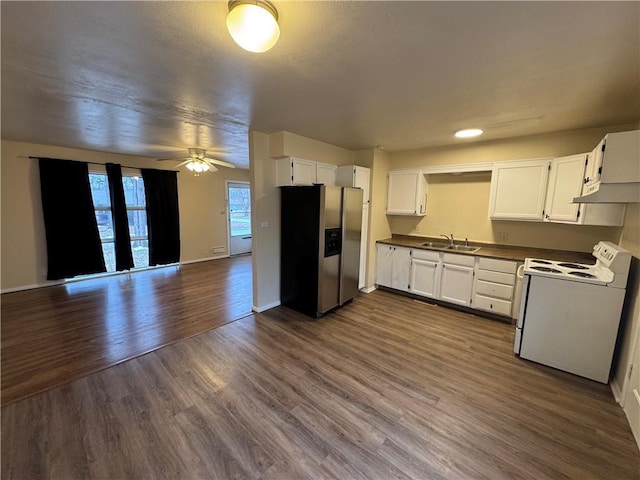 kitchen with a sink, white range with electric cooktop, stainless steel fridge, and white cabinetry