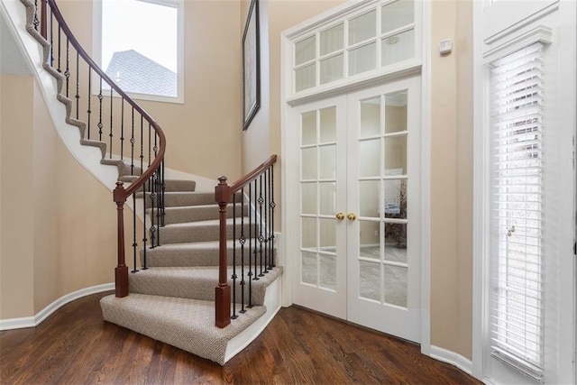 stairs featuring hardwood / wood-style floors and french doors