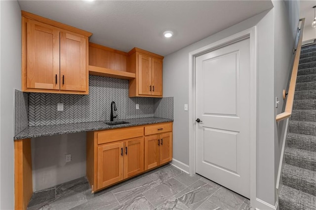 kitchen featuring dark stone countertops, sink, and backsplash