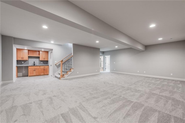 basement with sink and light colored carpet