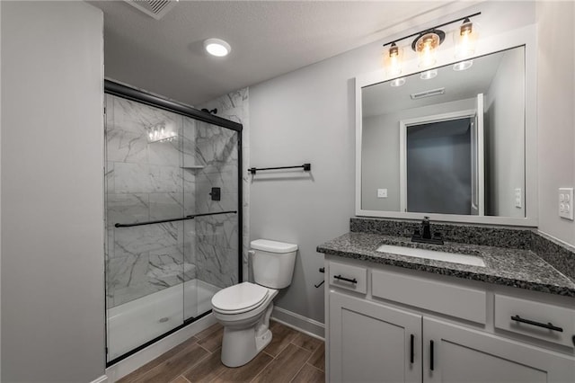 bathroom with walk in shower, vanity, and toilet