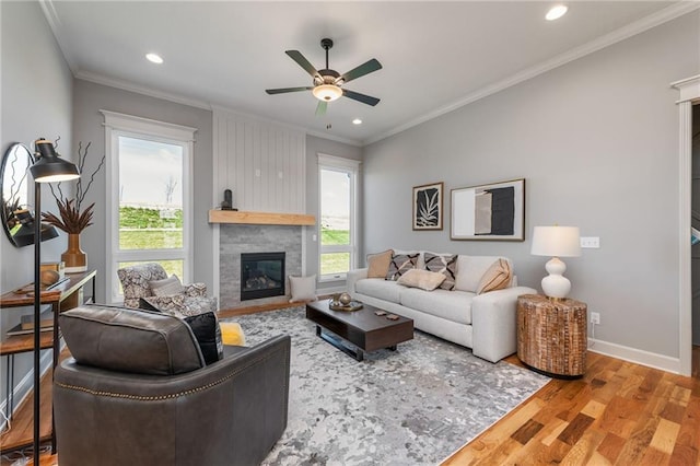 living room featuring wood-type flooring, a wealth of natural light, ceiling fan, and crown molding