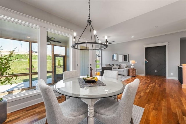 dining room featuring ceiling fan with notable chandelier and hardwood / wood-style floors