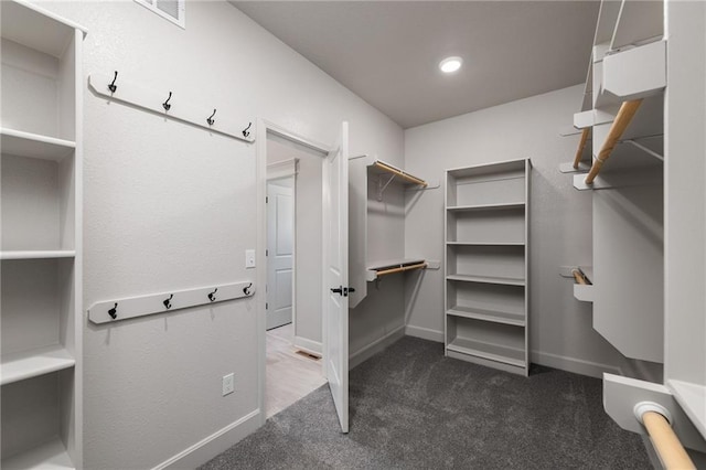 walk in closet featuring dark carpet